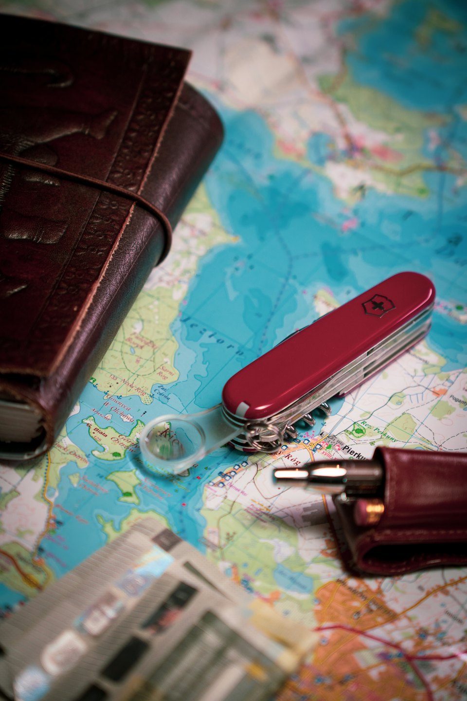 Reiseutensilien auf einer Karte ausgebreitet, mit einem Notizbuch und einem Multitool.